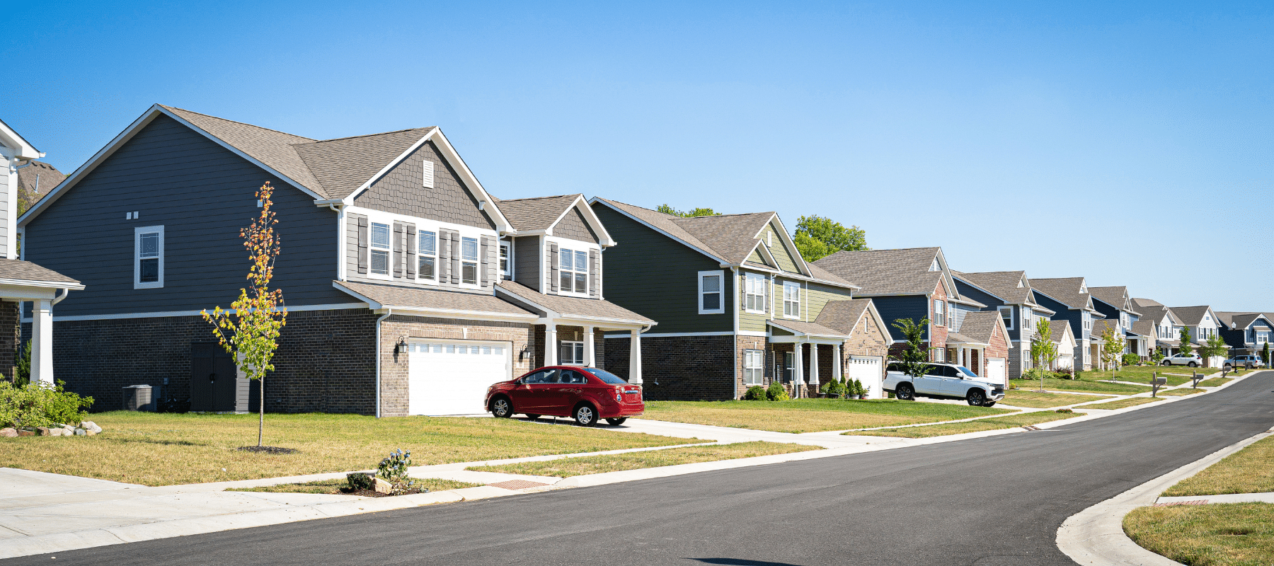 A row of modern suburban homes with well-maintained lawns